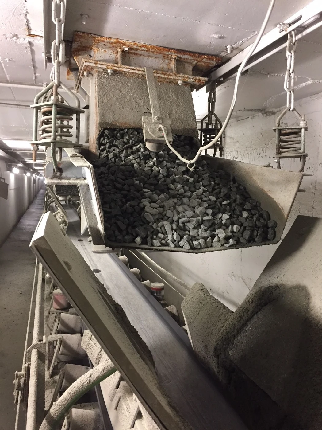 Aggregate discharging from a bin gate onto a plant conveyor