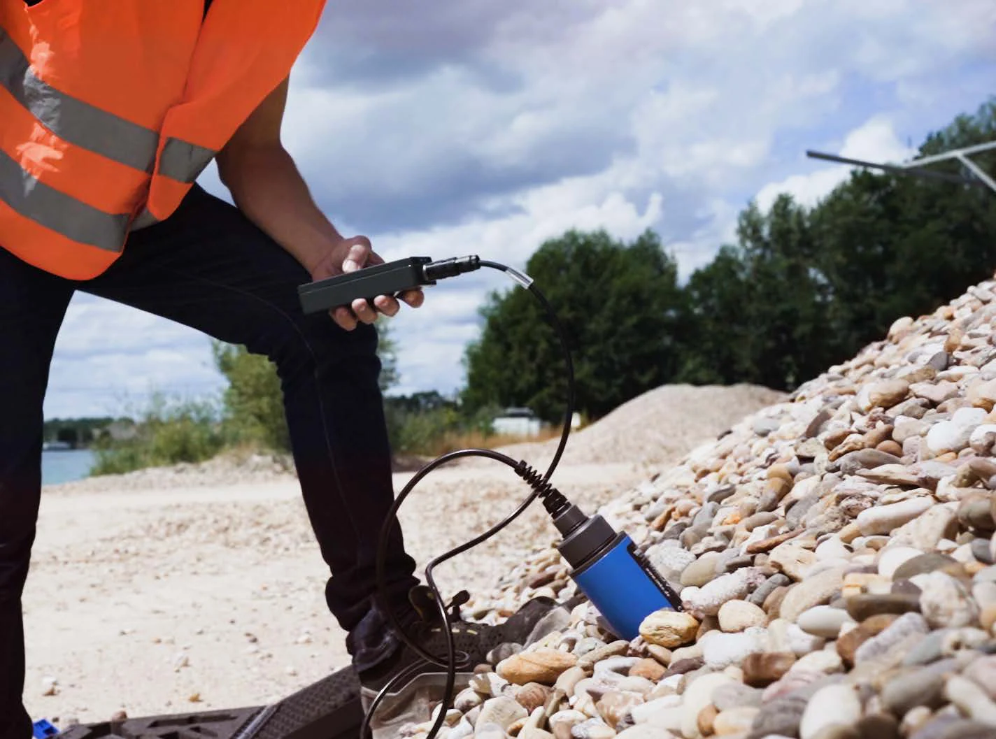 Operator taking a sand moisture reading at a stockpile with the HD2 portable meter